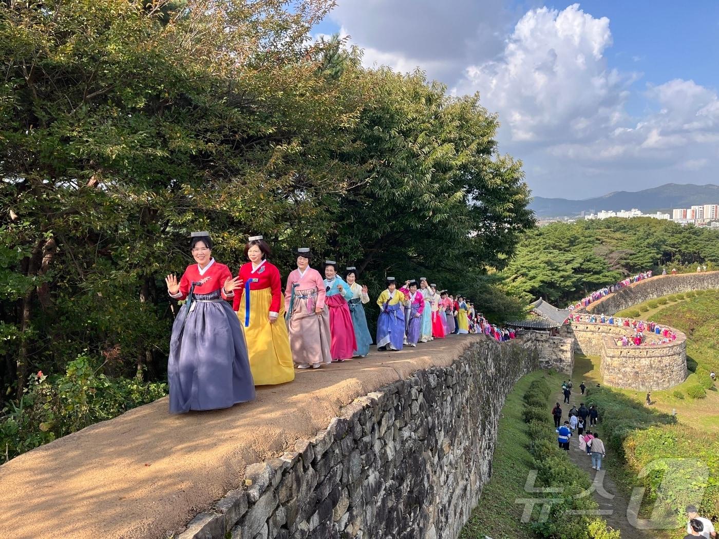 본문 이미지 - 1일 전북 고창군에서 '모양성제'의 하이라이트 ‘답성놀이’가 열리고 있다. 머리 위에 돌을 올리고 성을 한 바퀴 돌면 다리병이 낫고, 두 바퀴 돌면 무병장수하고, 세 바퀴 돌면 극락왕생 한다는 전설이 있다.(고창군제공. 재판매 및 DB금지)2025.11.1/뉴스1 ⓒ News1 김동규 기자