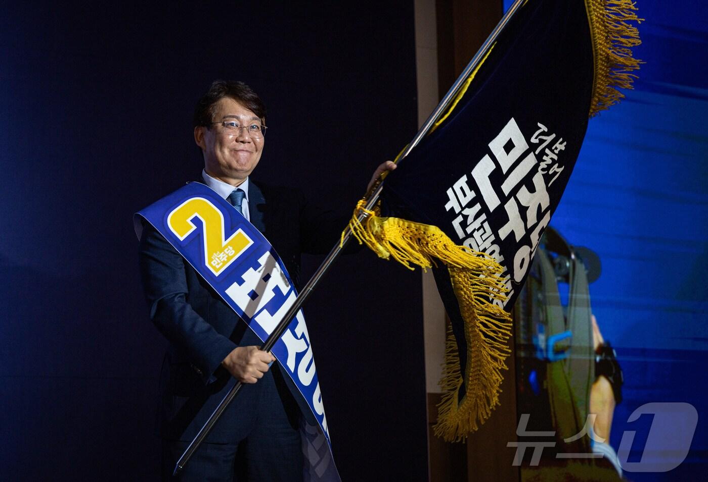 변성완 신임 더불어민주당 부산시당위원장이 1일 부산 해운대구 벡스코에서 열린 민주당 부산시당 임시당원대회에서 부산시당기를 흔들고 있다. (더불어민주당 제공. 재판매 및 DB 금지)