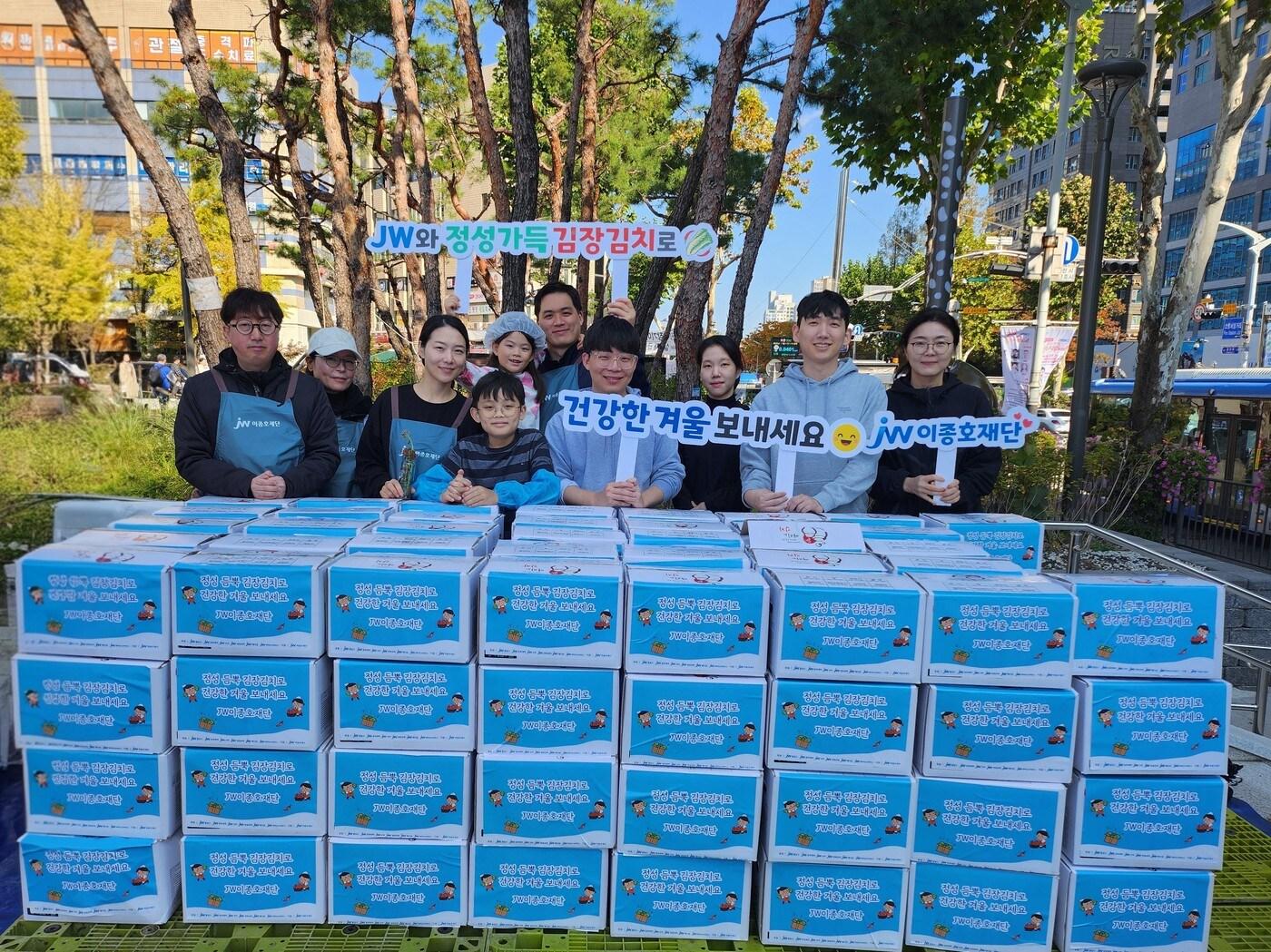 본문 이미지 - JW 임직원들이 지난 1일 과천시민회관 시계탑 광장에서 열린 ‘2025년 모두가 나누는 김장축제’에서 기념촬영을 하고 있다. &#40;JW홀딩스 제공&#41;