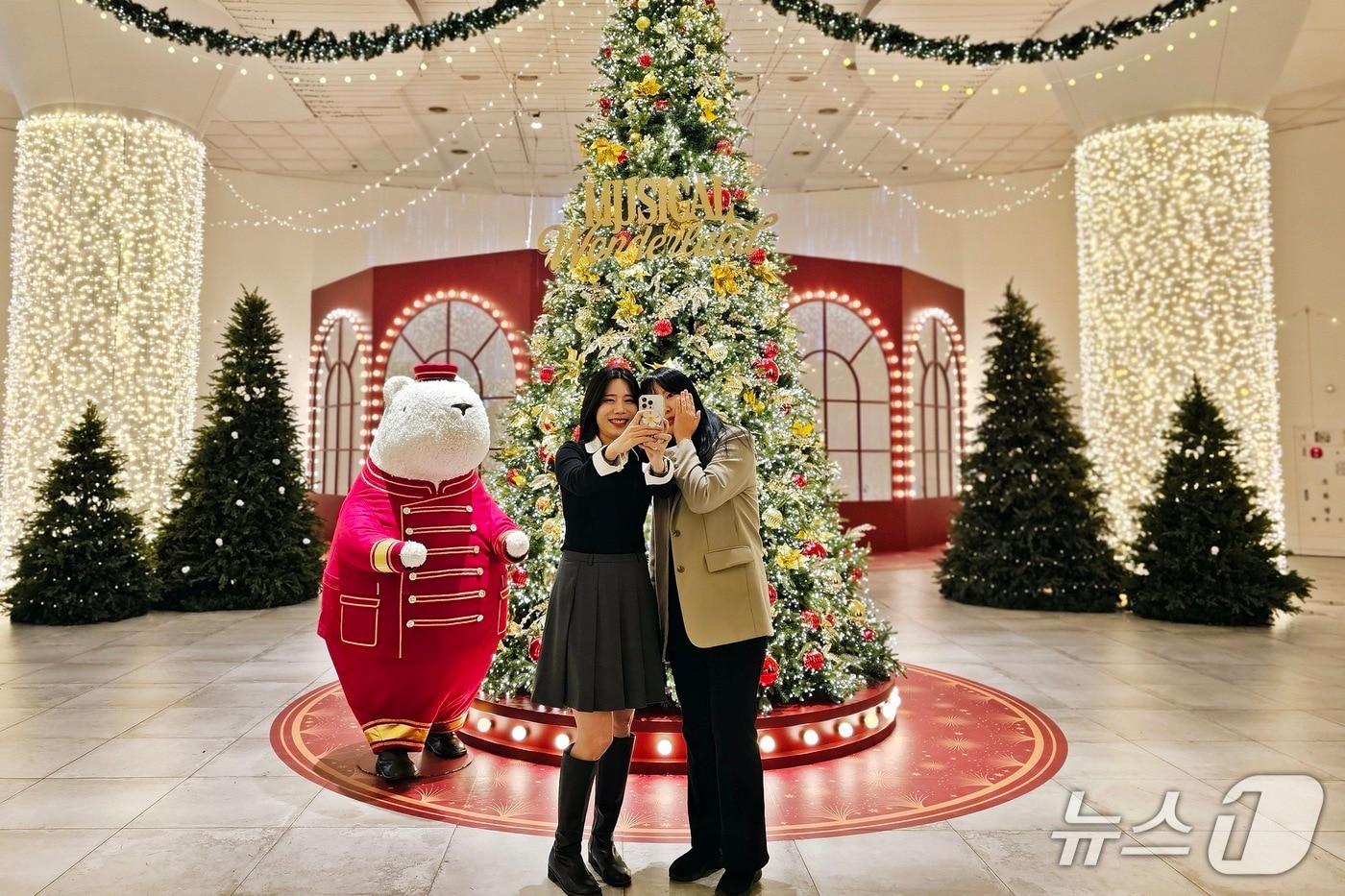 신세계백화점 센텀시티를 방문한 고객들이 백화점 지하 2층에 마련된 메인트리 앞에서 기념사진을 찍고 있다.&#40;신세계백화점 센텀시티 제공. 재판매 및 DB 금지&#41;