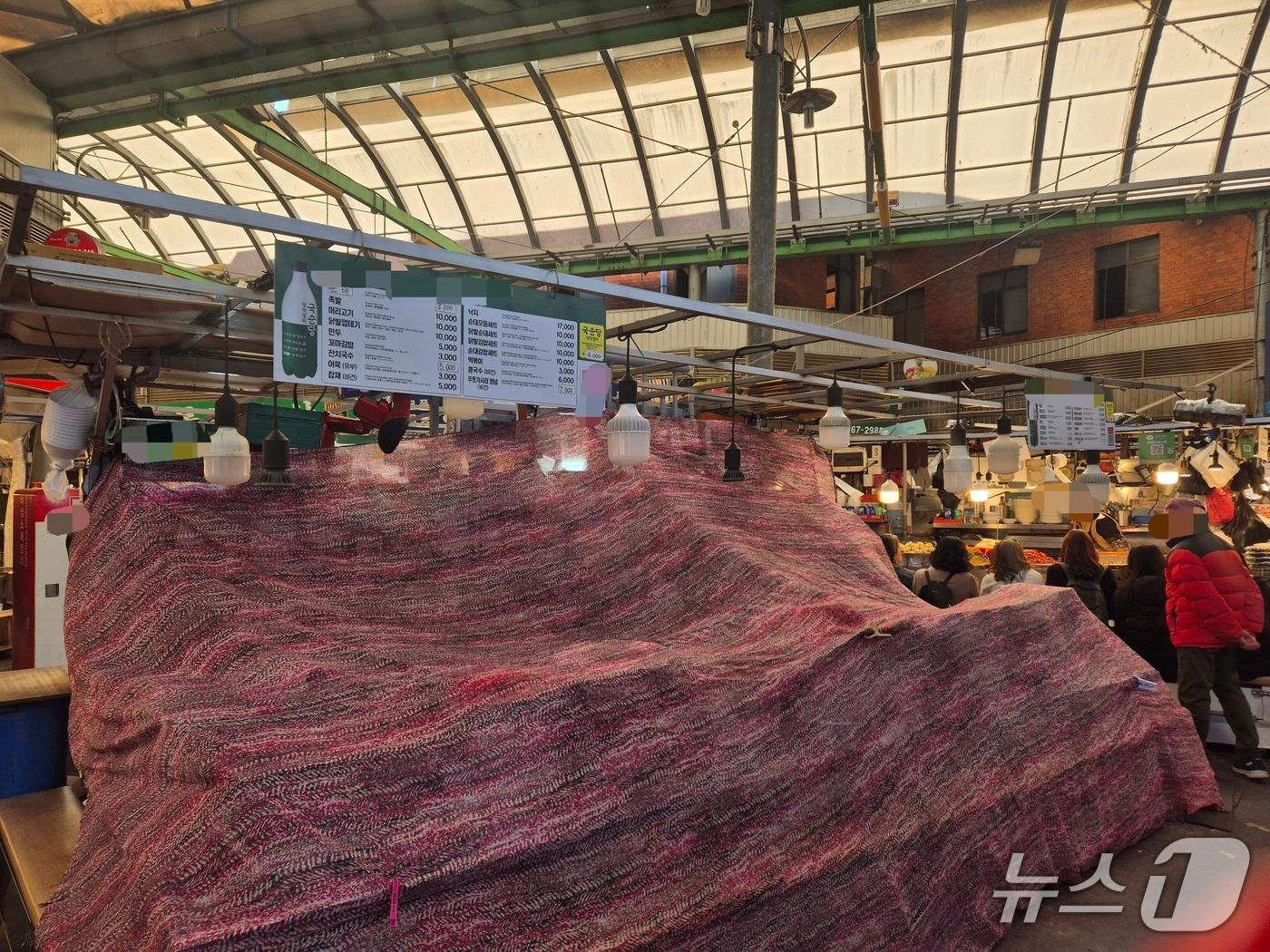 본문 이미지 - 10일 서울 종로구 광장시장에서 바가지 논란이 불거진 한 노점이 천막으로 덮여 영업을 하지 않는 모습. 2025.11.10/뉴스1 ⓒ News1 신윤하 기자