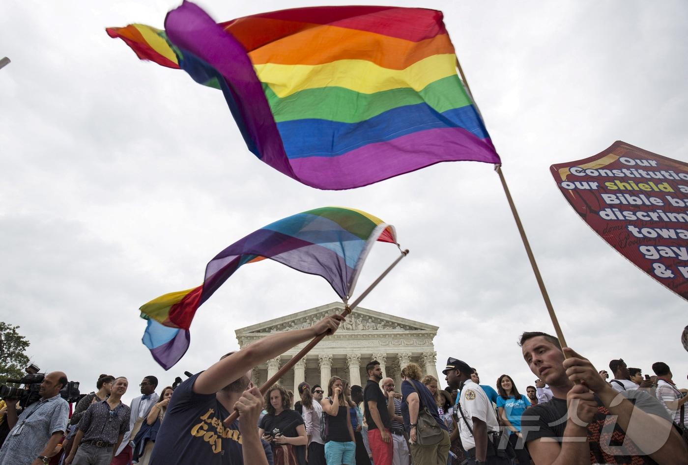 지난 6월 26일 워싱턴DC 소재 연방 대법원에서 동성 커플에게 결혼할 권리를 보장한다는 판결이 내려진 후 동성 결혼 지지자들이 성소수자 공동체를 상징하는 무지개 깃발을 흔들고 있다. 2025.11.10. ⓒ 로이터=뉴스1 ⓒ News1 류정민 특파원