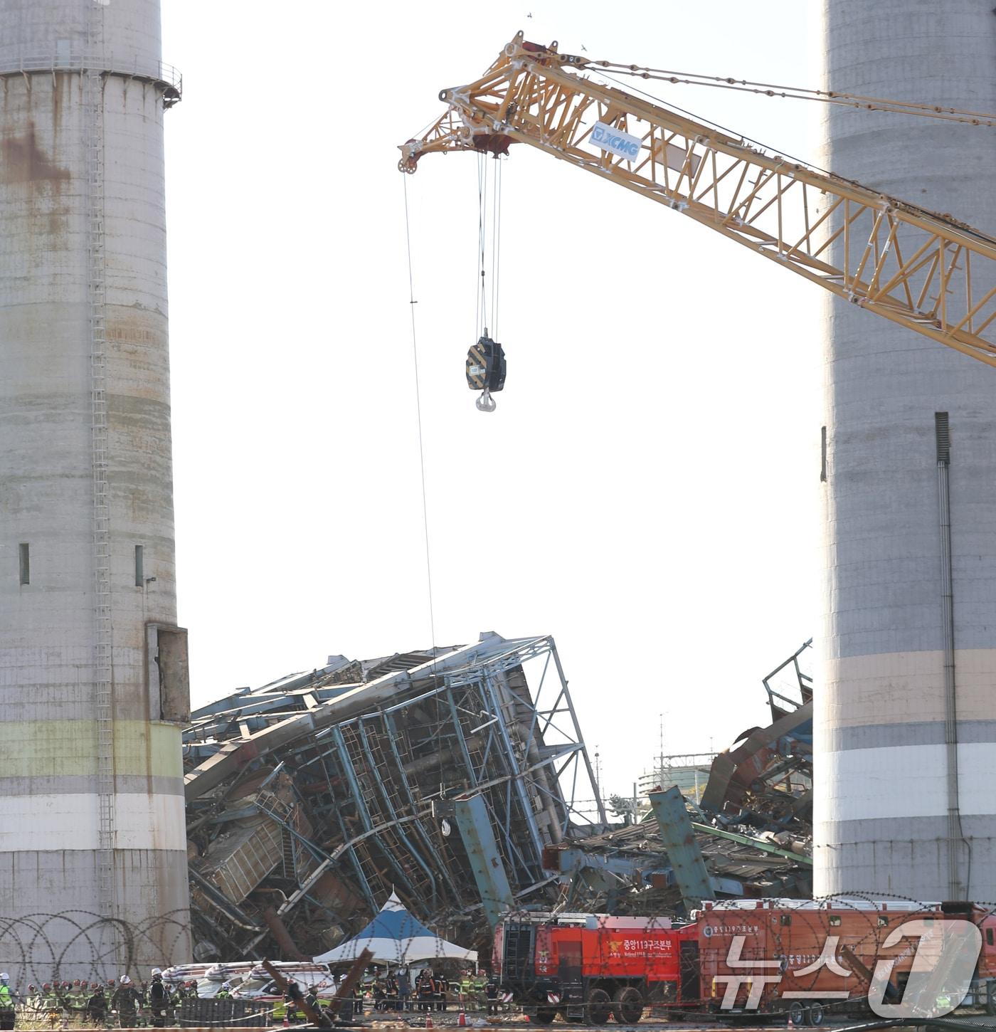 본문 이미지 - 11일 울산 남구 남화동 한국동서발전 울산화력발전소 보일러 타워 붕괴 현장에서 소방대원들이 구조·수색 준비 작업을 하고 있는 가운데 크레인이 배치되고 있다. 2025.11.11/뉴스1 ⓒ News1 조민주 기자