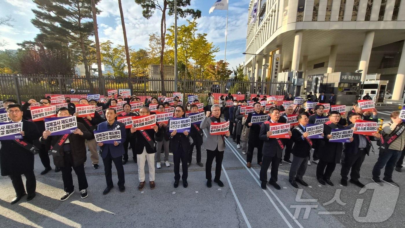 11일 오후 세종시 정부세종청사 보건복지부 앞에서 열린 '검체검사 제도개편 강제화 전면 중단 촉구 대표자 궐기대회'에서 김택우 대한의사협회 회장과 참가자들이 피켓을 들고있다. (대한의사협회 제공. 재판매 및 DB 금지)