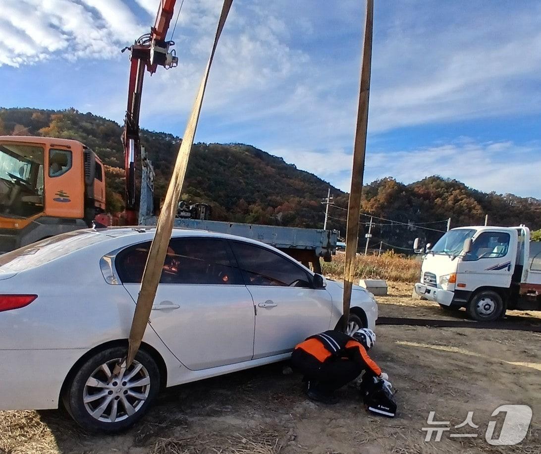 본문 이미지 - 11일 오후 3시24분쯤 경북 안동시 남후면 광음리의 공터에서 크레인으로 승용차를 들어올려 작업하던 중 갑자기 차가 떨어져 사람이 깔리는 사고가 발생했다.(경북소방본부 제공. 재판매 및 DB금지)2025.11.12/뉴스1