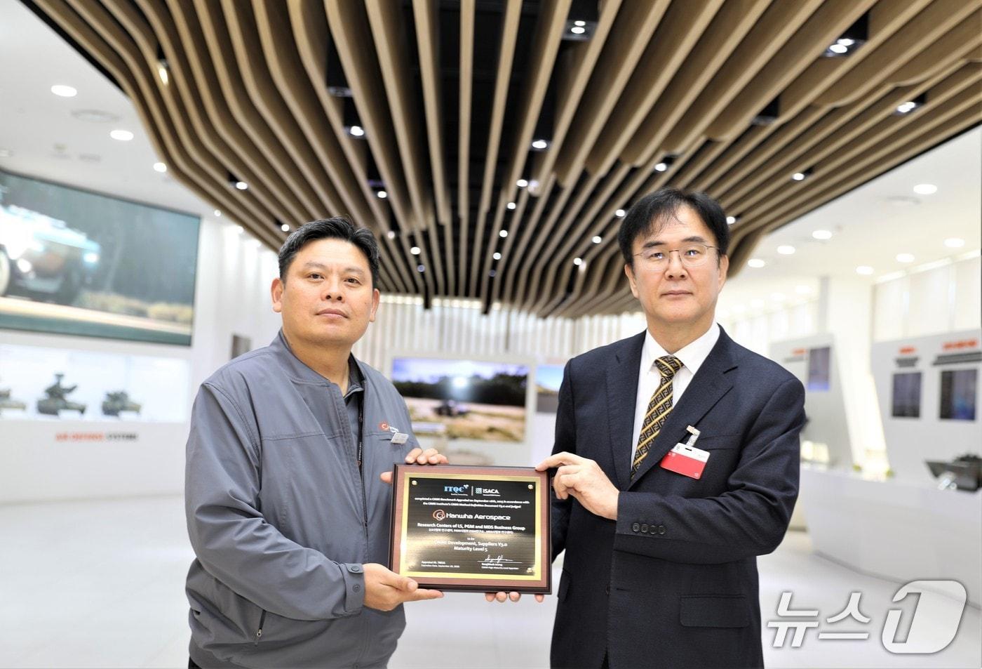 안홍규 한화에어로스페이스 임원과 정상욱 CMMI High Maturity 선임심사원&#40;ITQC 대표&#41;이 인증 후 기념촬영을 하고 있다&#40;한화에어로 제공&#41;