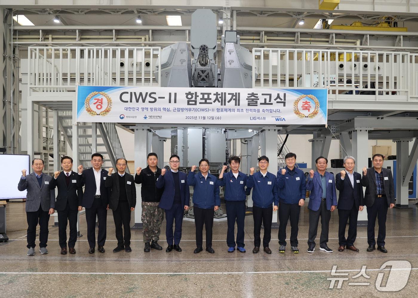 본문 이미지 - 12일 경남 창원의 현대위아 해상조립장에서 열린 해상용 근접방어무기&#40;CIWS-II&#41; 함포체계 출고식에서 권오성 현대위아 대표이사&#40;가운데&#41;와 최대근 방위사업청 중령&#40;왼쪽 여섯 번째&#41;, 최준호 해군 중령&#40;왼쪽 다섯 번째&#41;, 홍성표 LIG넥스원 CIWS-II 체계개발단장&#40;왼쪽 세 번째&#41;이 기념 사진을 촬영한 모습&#40;현대위아 제공&#41;. 2025.11.12.