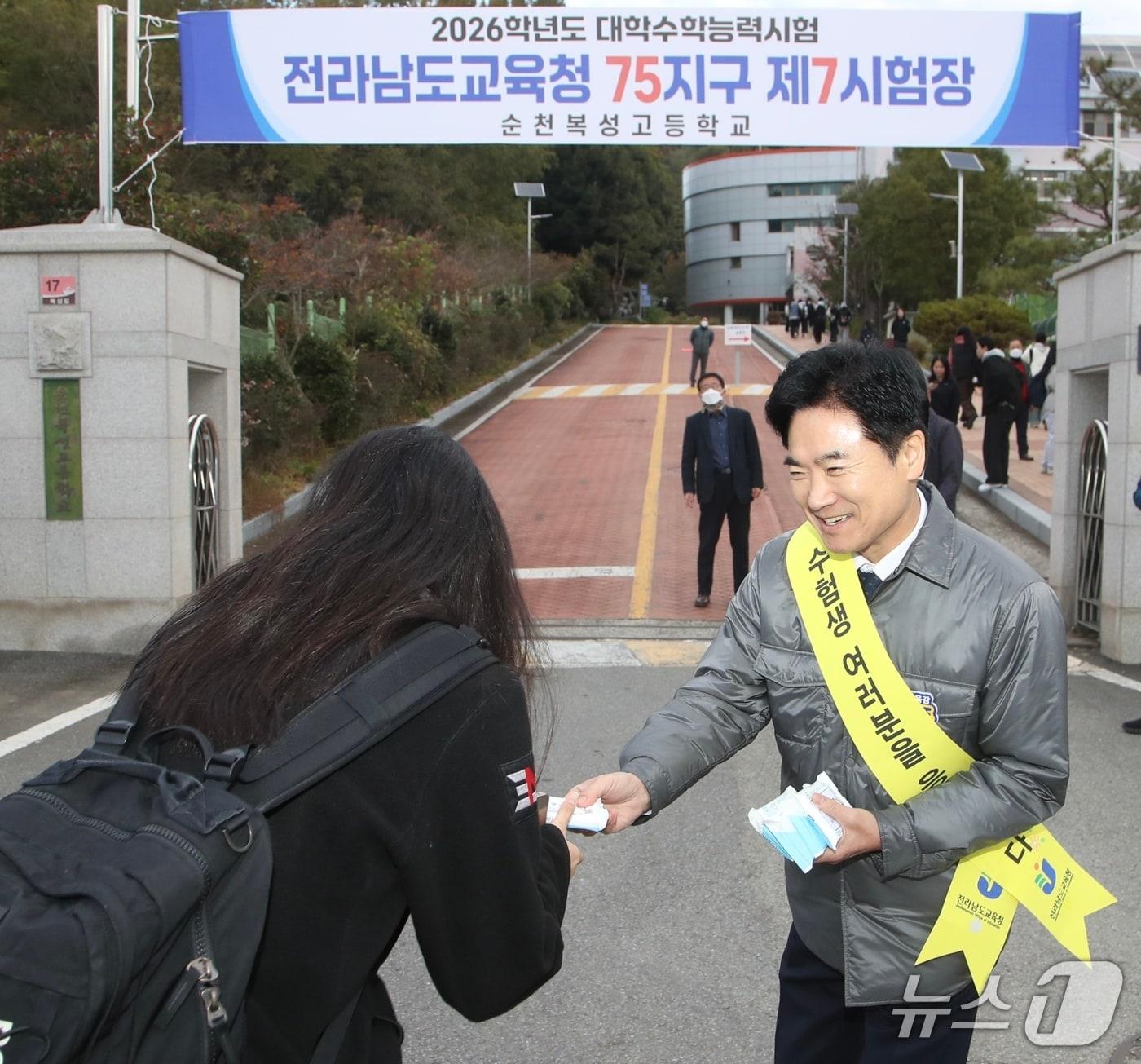 본문 이미지 - 김대중 전남교육감이 순천복성고등학교 교문에서 수험생들에게 핫팩을 전하며 격려하고 있다.&#40;전남교육청 제공, 재판매 및 DB금지&#41;/뉴스1 