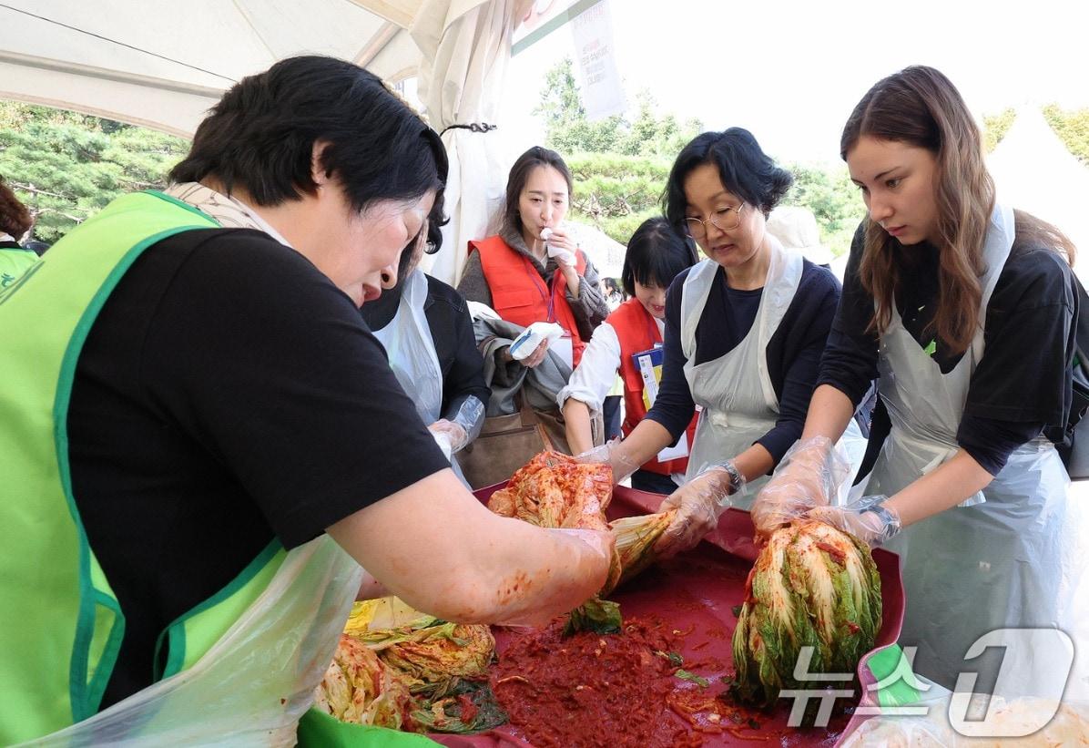 본문 이미지 - 스위스에서 온 관광객들이 서울 중구 남산골한옥마을에서 열린 제1회 대한민국 김장김치 축제에서 김장 김치 담그기 체험을 하고 있다. 2024.10.16/뉴스1