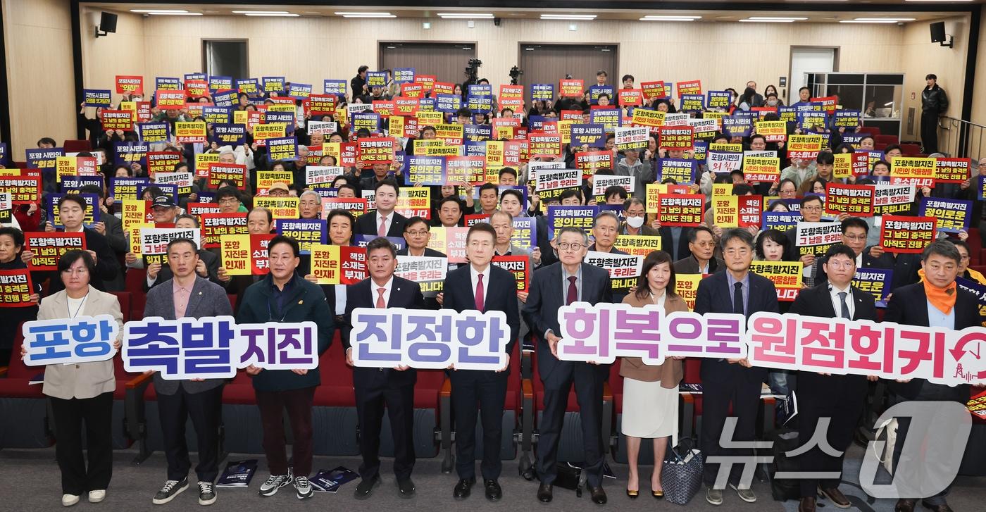 13일 경북 포항 흥해도서관에서 열린 '포항지진 국제포럼'에 참석한 시민들이 정부에 책임자 처벌과 정신적 피해 보상을 요구하며 피켓팅 퍼포먼스를 펼치고 있다. 2025.11.13/뉴스1 ⓒ News1 최창호 기자