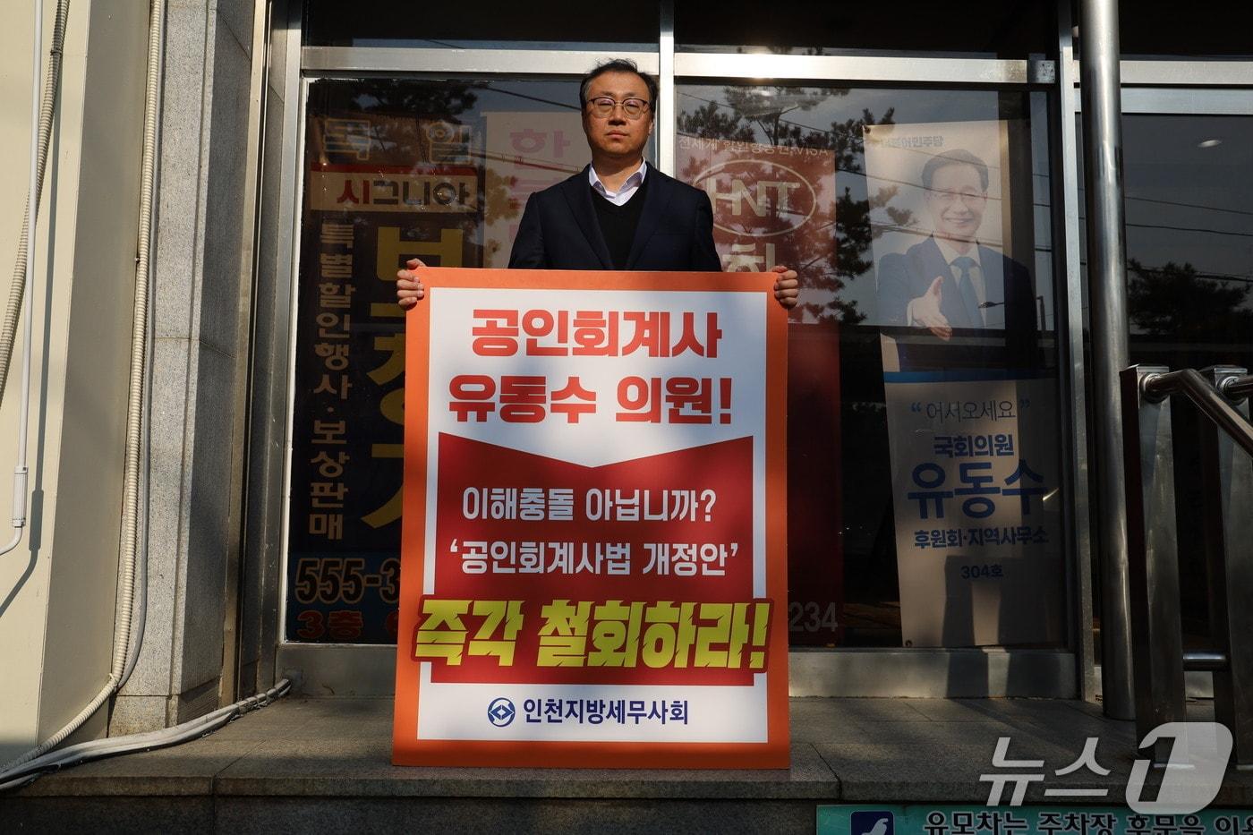 유동수 의원&#40;민주·인천 계양구갑&#41;이 회계사를 &#39;세무전문가&#39;로 규정하는 내용의 법안을 발의하자 한국세무사 측이 &#34;전문자격사 제도의 근간을 훼손하는 것&#34;이라며 반발했다. 사진은 지난 12일 이현섭 계양지역세무사회장이 유 의원 지역사무실 앞에서 1인 시위를 하고 있는 모습.&#40;한국세무사회 제공&#41;/