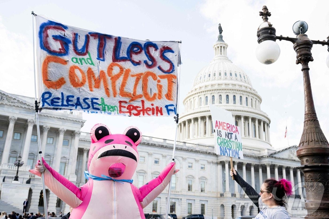 12일&#40;현지시간&#41; 워싱턴DC 미국 국회의사당 밖에서 한 시위자가 제프리 엡스타인 사건 파일 공개 관련 팻말을 들고 있다. 미국 민주당은 13일 엡스타인이 자신의 성적 학대 사실을 도널드 트럼프 미국 대통령이 알고 있었고, 트럼프 대통령이 피해자 중 한 명과 집에서 &#34;몇 시간을 보냈다＂는 내용을 담은 이메일을 공개했다. ⓒ AFP=뉴스1 ⓒ News1 이정환 기자