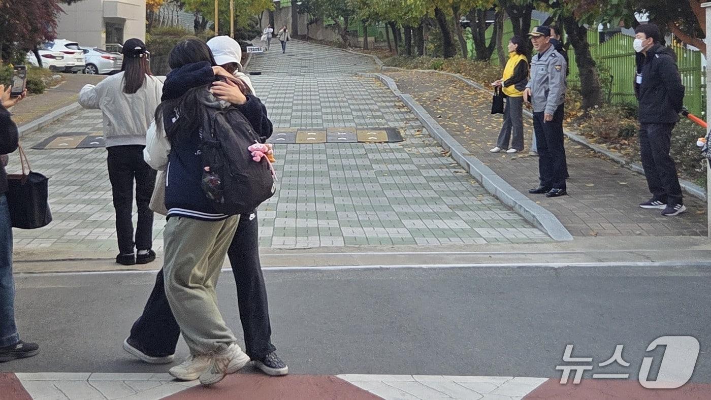 13일 오후 대구 수성구 대구여고에서 2026학년도 수학능력시험을 마친 한 수험생이 어머니 품에 안겨 있다.2025.11.13/뉴스1