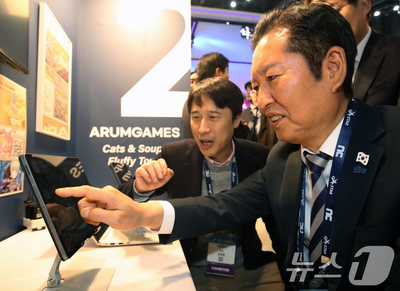 본문 이미지 - 정청래 더불어민주당 대표가 14일 오후 부산 해운대구 벡스코 제1전시장에서 열린 국내 최대 게임전시회 '지스타 2025'에서 부스를 둘러보며 게임을 체험하고 있다. 2025.11.14/뉴스1 ⓒ News1 윤일지 기자