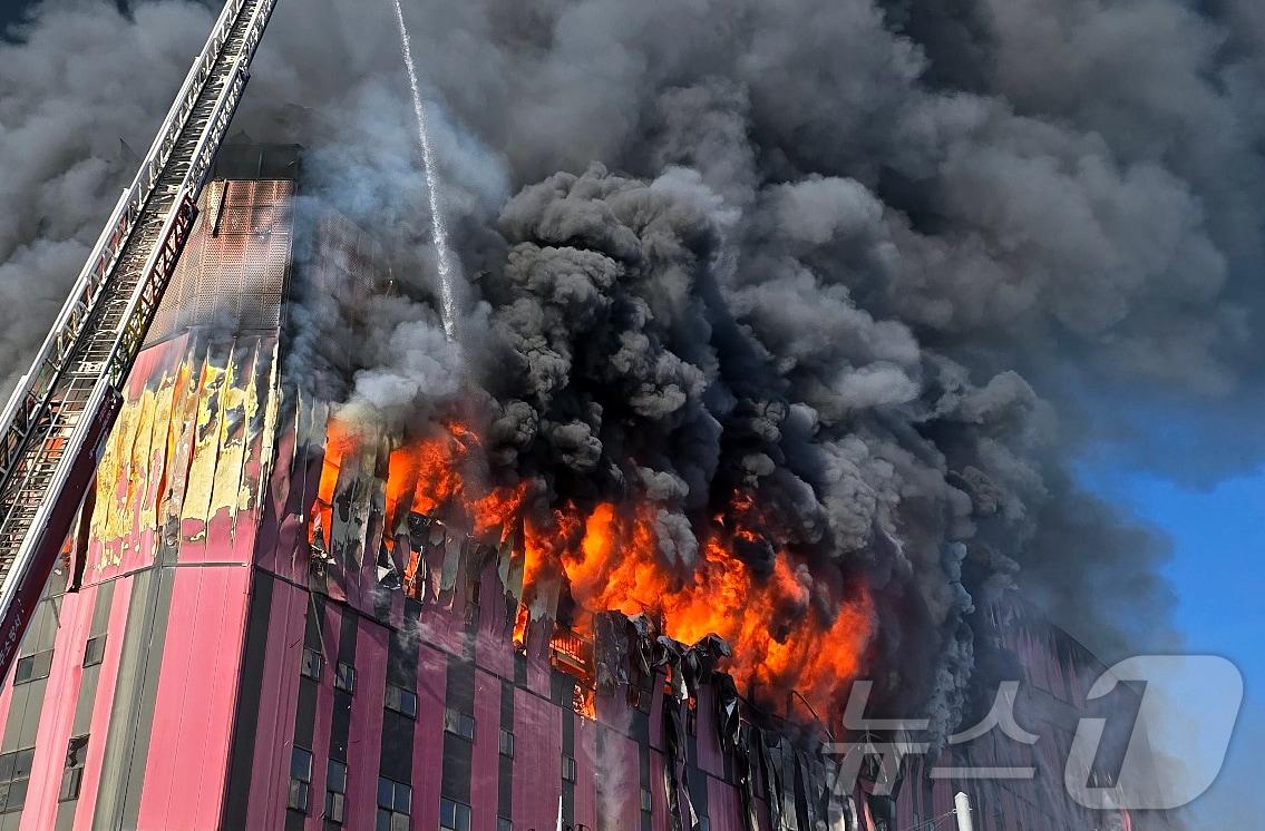 본문 이미지 - 15일 오전 충남 천안 동남구 이랜드패션 물류센터에서 화재가 발생해 검은 연기와 함께 화염이 치솟고 있다. 소방 당국은 대응 2단계로 격상해 화재를 진화 중이다. 2025.11.15/뉴스1 ⓒ News1 이시우 기자