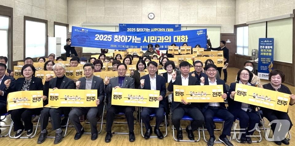 본문 이미지 - 우범기 전주시장이 지난 14일 효자1동 주민들과 소통한 뒤 완주전주 통합을 원하는 팻말을 들고 기념사진을 촬영하고 있다.&#40;전주시 제공, 재판매 및 DB 금지&#41;/뉴스1