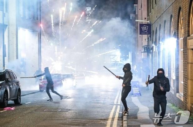 본문 이미지 - 영국의 한 &#39;불꽃 축제&#39; 기간 중 청소년들이 도로에서 행인들을 향해 폭죽을 던지고있다. 출처=더선