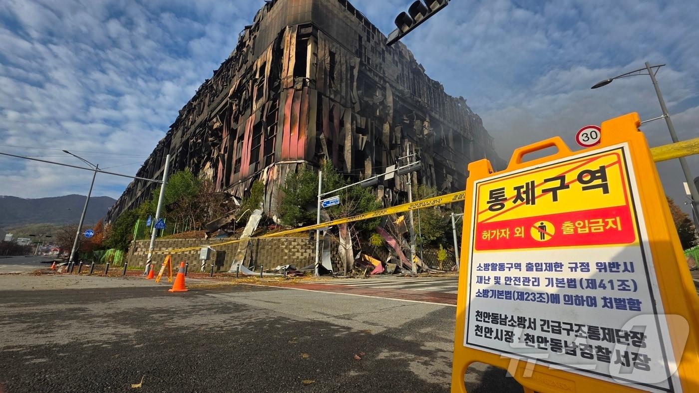 충남 천안 동남구 이랜드패션 물류센터 화재 이틀 째인 16일, 화재 현장 주변에 출입 금지 표지판이 설치돼 있다. 소방당국은 대응1단계를 유지한 채 화재 진압을 이어가고 있다. 2025.11.16/뉴스1 ⓒ News1 이시우 기자