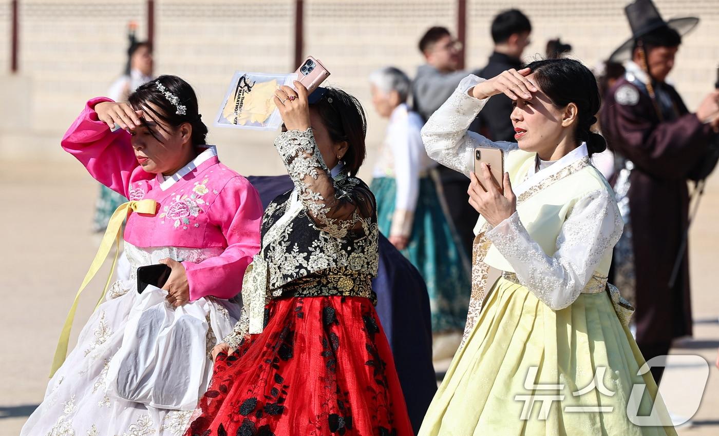 포근한 날씨를 보인 16일 서울 종로구 경복궁을 찾은 관광객들이 손으로 햇볕을 가리며 이동하고 있다. 2025.11.16/뉴스1 ⓒ News1 김도우 기자