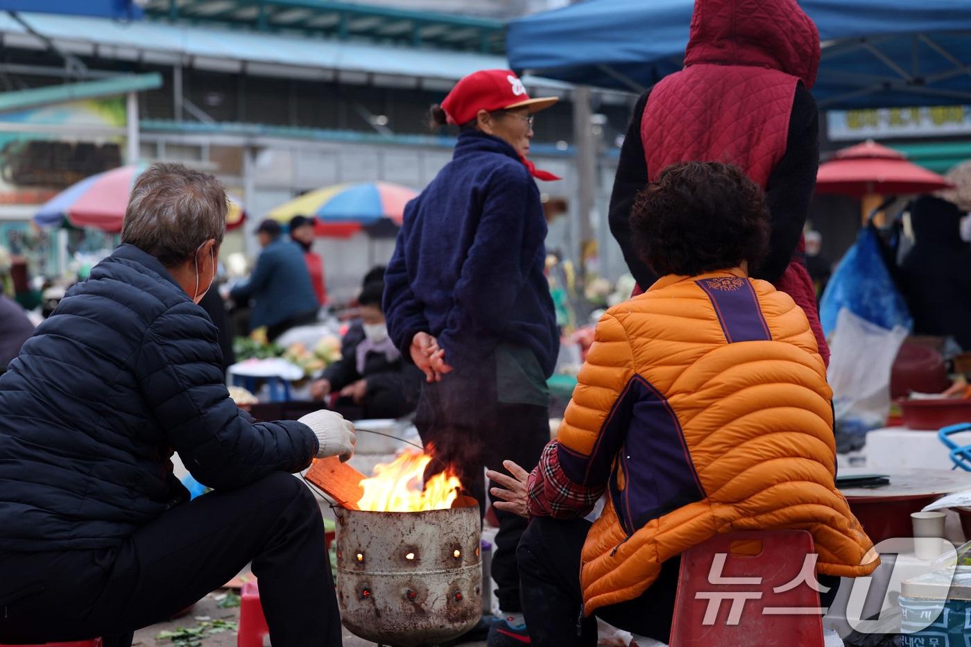 광주 무등산 아침최저기온이 -3.3도를 기록한 18일 오전 광주 동구 남광주시장 상인들이 추위를 피하기 위해 불을 쬐고 있다. ⓒ News1 박지현 기자