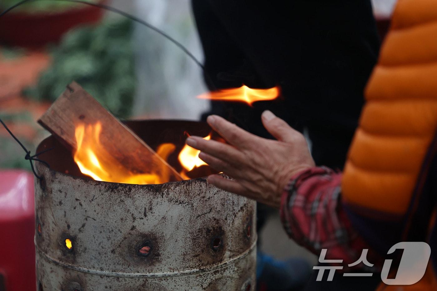 광주 무등산 아침최저기온이 -3.3도를 기록한 18일 오전 광주 동구 남광주시장 상인들이 추위를 피하기 위해 불을 쬐고 있다. 2025.11.18/뉴스1 ⓒ News1 박지현 기자