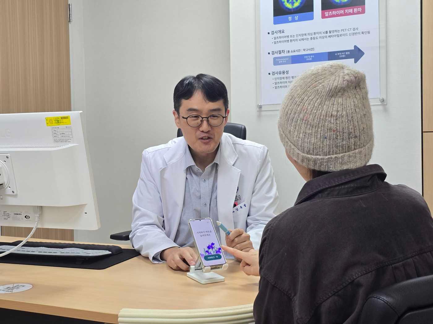 본문 이미지 -  용인세브란스병원 정신건강의학과 김우정 교수가 경도인지장애 환자에게 이모코그 경도인지장애 디지털치료기기 &#39;코그테라&#39;&#40;Cogthera&#41;의 사용 방법을 설명하고 있다. &#40;이모코그 제공&#41;