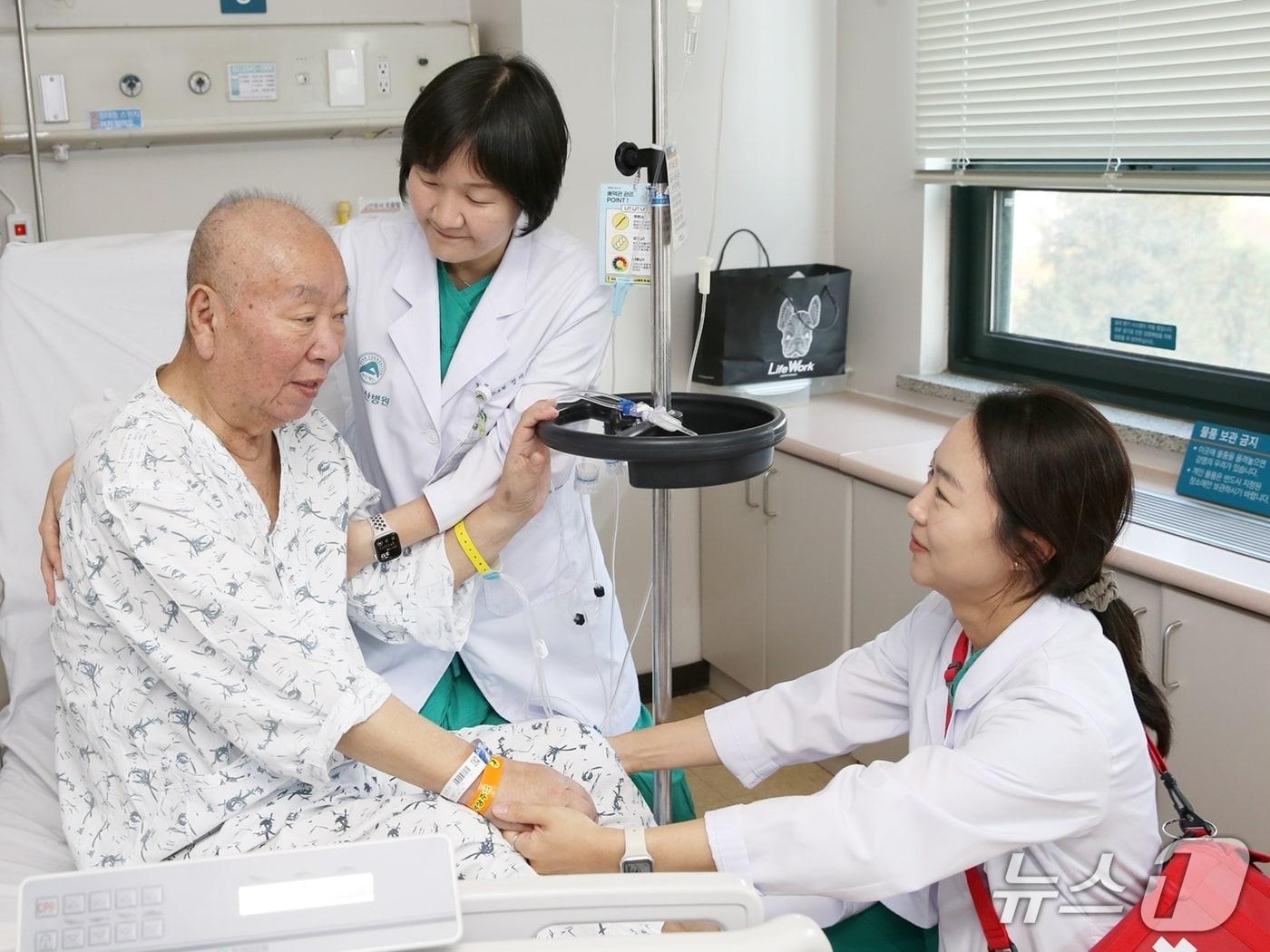 본문 이미지 - 서울아산병원 낙상대응팀이 낙상 환자에게 폴대를 이용한 안전한 이동 방법을 교육하고 있다.&#40;서울아산병원 제공&#41;