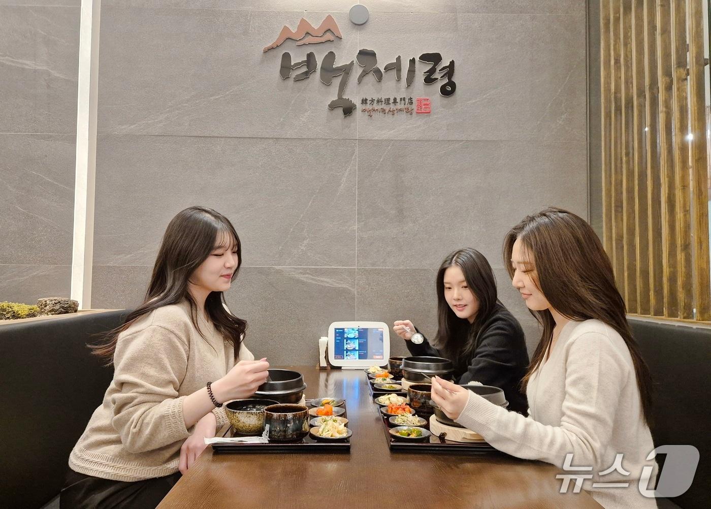 본문 이미지 - 롯데백화점 광복점을 방문한 고객들이 백제령 삼계탕의 음식을 맛보고 있다.(롯데백화점 광복점 제공. 재판매 및 DB 금지)