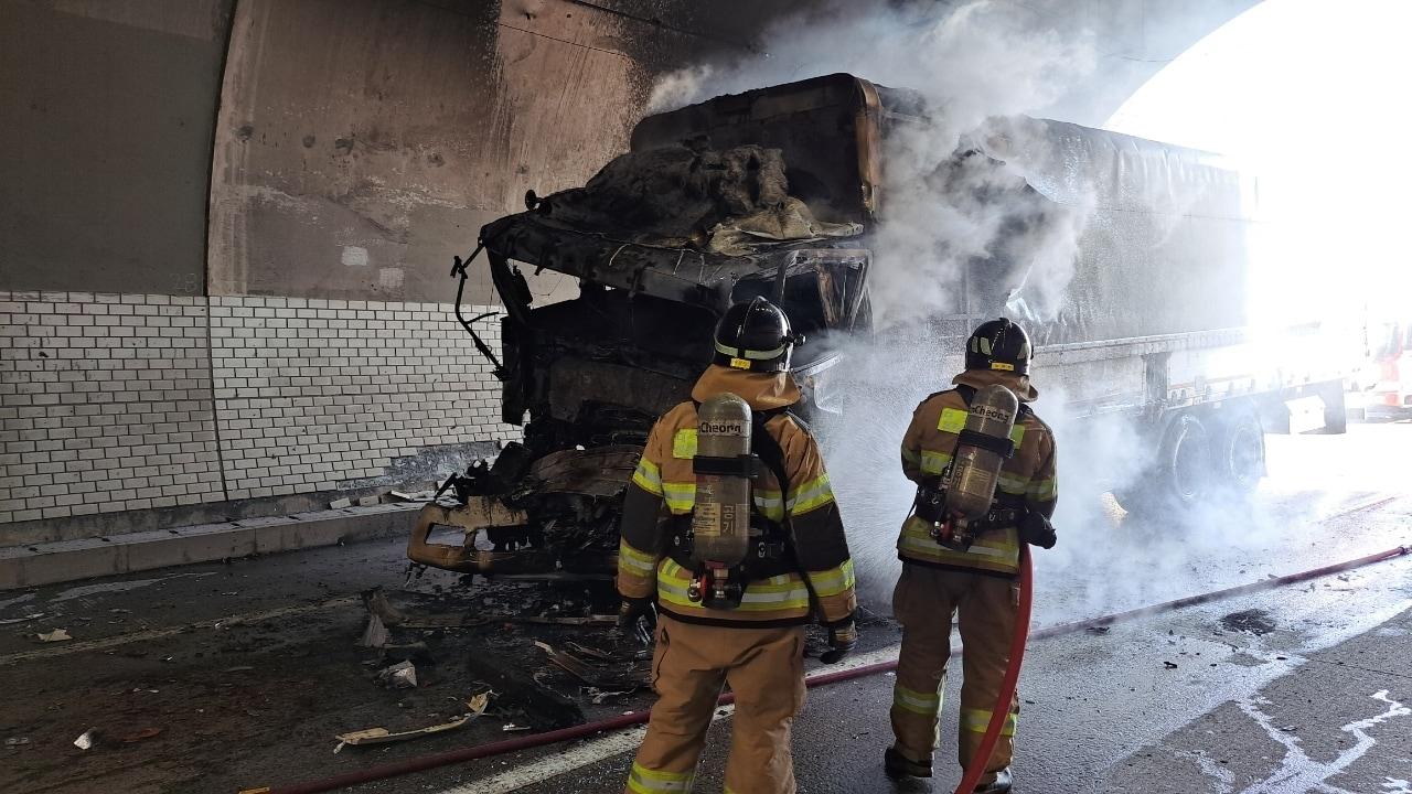 본문 이미지 - 18일 낮 12시 34분쯤 중부내륙고속도로 양평 방향 58㎞ 지점 고령2터널에서 화물차가 앞서가던 화물차 2대를 들이받는 사고로 추돌한 화물차 1대에 불이 붙어 출동한 소방관이 진화작업을 하고 있다. &#40;경북소방본부 제공. 재판매 및 DB금지&#41;/뉴스1