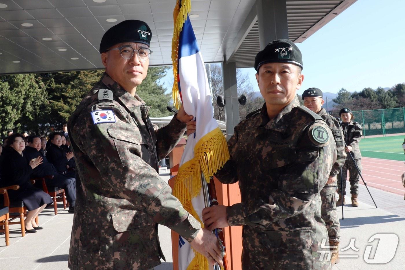 정유수&#40;오른쪽&#41; 신임 2군단장이 18일 2군단에서 열린 제50·51대 군단장 이·취임식에서 주성운 지상작전사령관에게 부대기를 이양받고 있다. &#40;2군단 제공, 재판매 및 DB금지&#41;