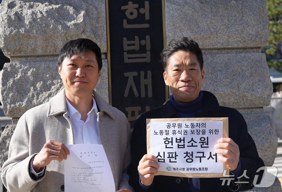 본문 이미지 - 문성호 강원 원주시청 공무원노동조합 위원장&#40;오른쪽&#41;과 정지욱 변호사가 18일 헌법재판소에 &#39;관공서의 공휴일에 관한 규정 제2조&#39;가 헌법에 위반된다는 내용의 헌법소원심판청구서를 제출한 가운데, 이에 앞서 재판소 앞에서 기념 사진을 촬영하고 있다. &#40;원주시청 공무원노동조합 제공. 재판매 및 DB금지&#41; 2025.11.18/뉴스1