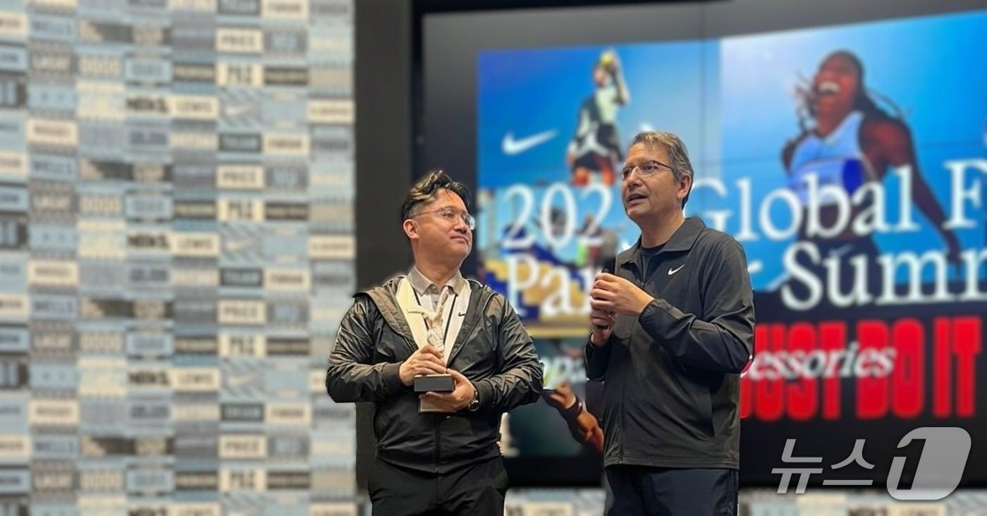 나이키가 최근 개최한 ‘2025 Global Factory Partner Summit’에서 테그라 황일서 대표&#40;왼쪽&#41;가 나이키 시니어 디렉터 마르코 두아르테로부터 우수 공급 파트너로 선정되며 트로피를 받는 모습. &#40;테그라 제공&#41;