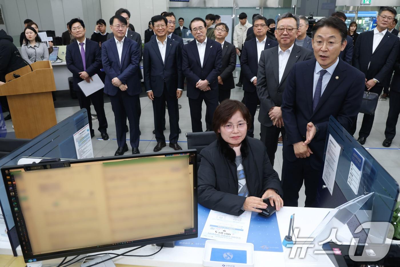 권대영 금융위원회 부위원장&#40;앞줄 오른쪽&#41;이 19일 오전 서울 중구 신한은행 광교영엉부 영업점을 찾아 한 고객의 오프라인 오픈뱅킹·마이데이터 서비스를 이용모습을 바라보고 있다. 2025.11.19/뉴스1 ⓒ News1 이광호 기자