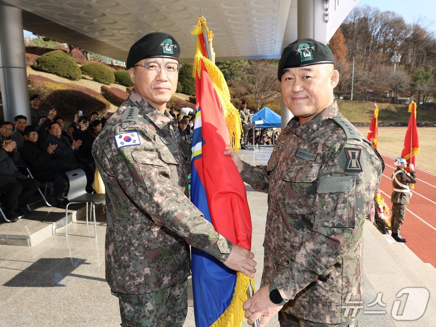 본문 이미지 - 19일 육군 제1군단장 취임식에서 주성운 지작사령관(왼쪽)이 한기성 신임 군단장에게 군단기를 전달하고 있다. (육군 제1군단 제공, 재판매 및 DB금지)