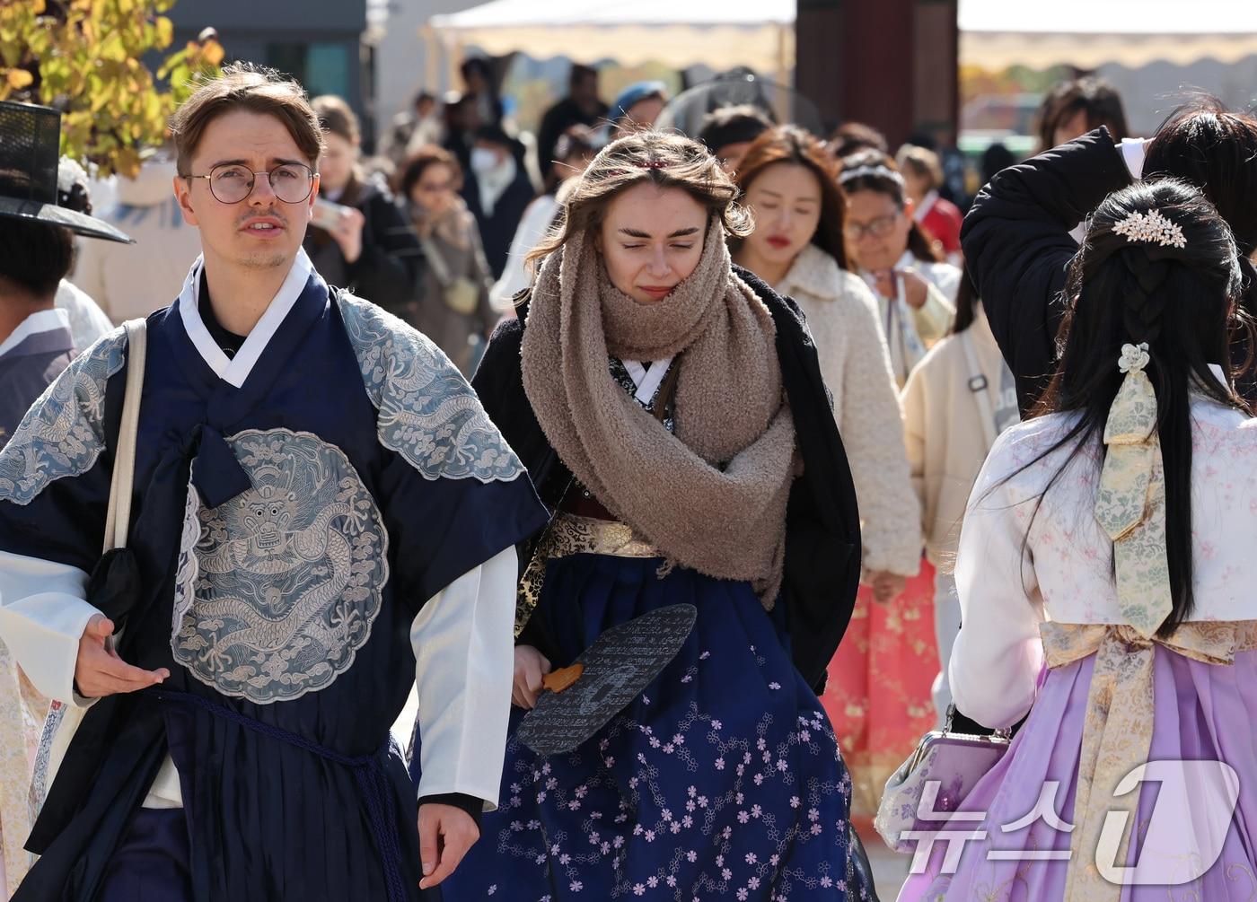 본문 이미지 - 지난 11월 2일 오후 서울 종로구 경복궁을 찾은 외국인 관광객이 두꺼운 목도리로 몸을 감싼 채 관광을 즐기고 있는 모습. 2025.11.2/뉴스1 ⓒ News1 장수영 기자