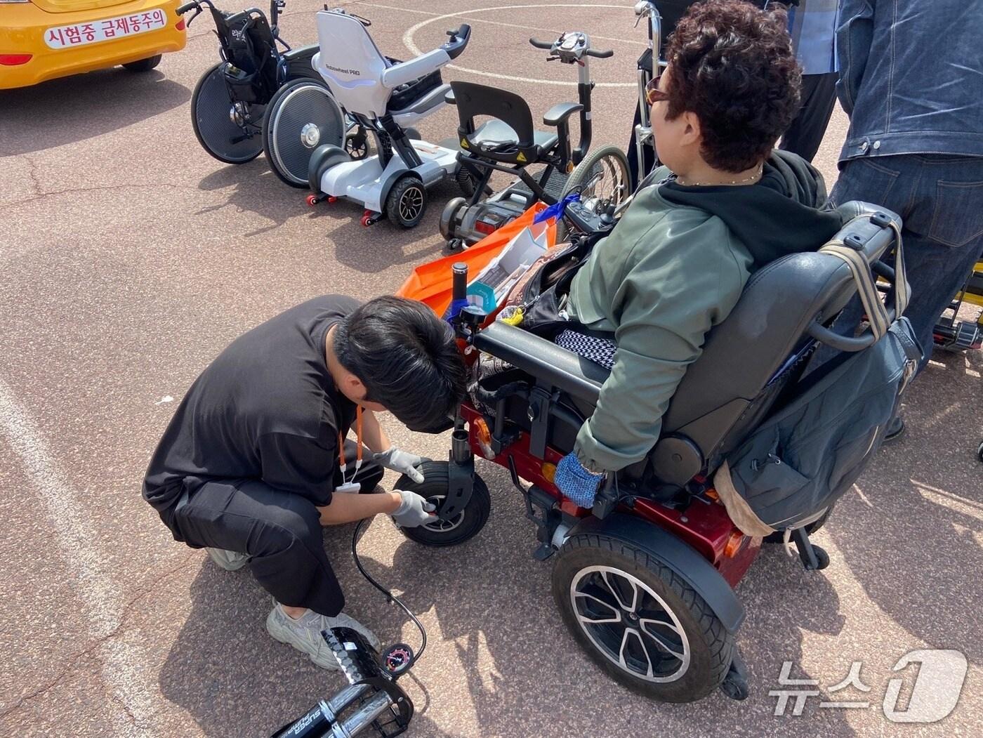 본문 이미지 - 전동휠체어 타이어 교체 작업 장면.(부산시 제공. 재판매 및 DB금지)