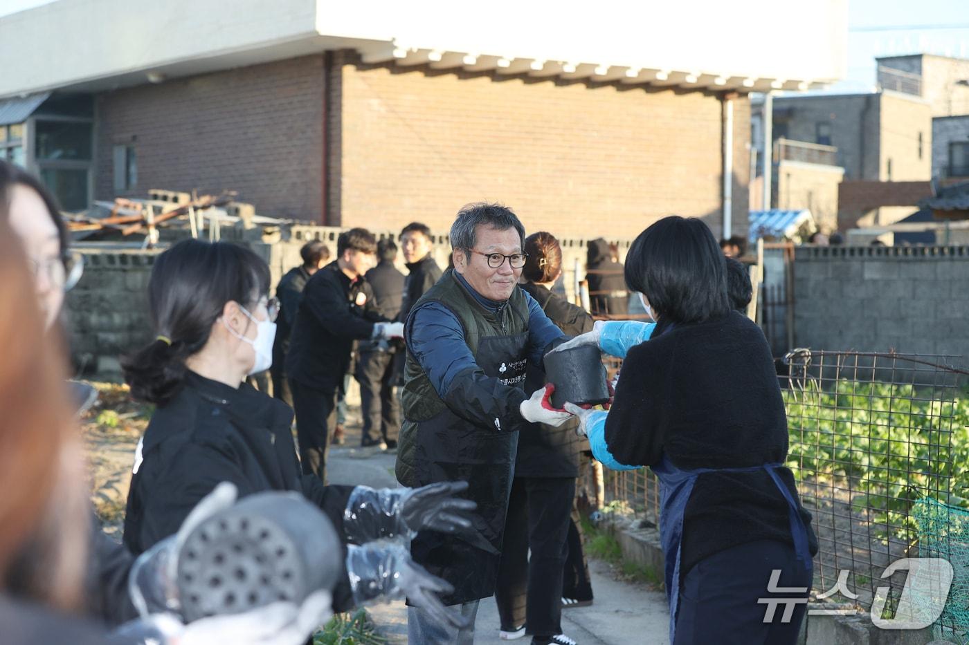 본문 이미지 - 김홍규 강원 강릉시장이 지난 21일 성덕동 일대에서 열린 연탄나눔 봉사활동에 참여해 연탄을 나르고 있다.(강릉시 제공, 재판매 및 DB 금지) 2025.11.22/뉴스1