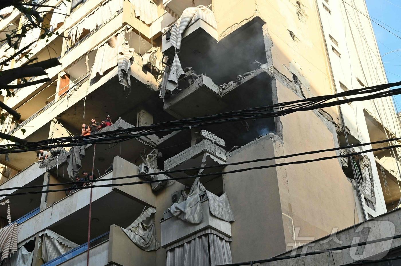     레바논 베이루트 남부 교외 하레트 흐레이크(Haret Hreik) 지역에서 이스라엘 공습으로 파괴된 주거 건물 현장에서 구조대원들이 생존자를 수색하고 있다. /2023.11.23ⓒ AFP=뉴스1