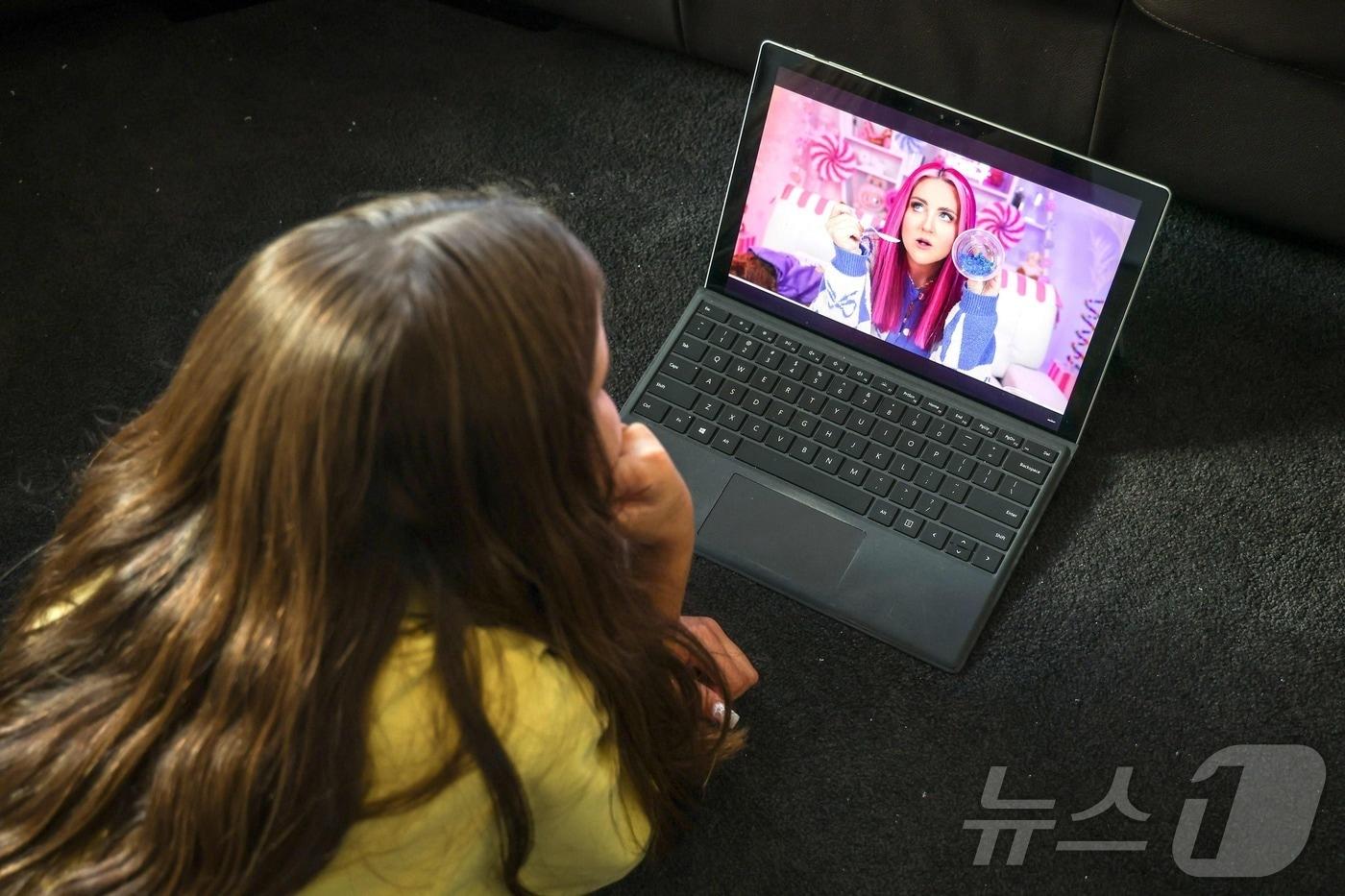 지난달 30일 호주의 한 어린이가 유튜브로 영상을 시청하며 바닥에 누워 있다. 2025.10.30. ⓒ AFP=뉴스1 ⓒ News1 이정환 기자