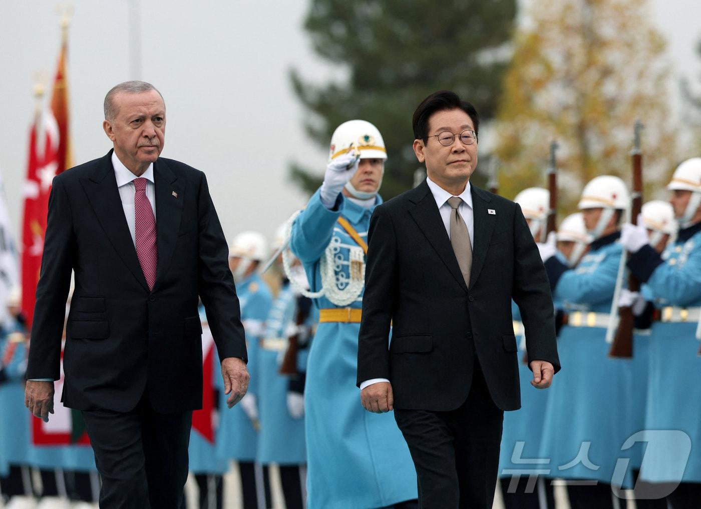 본문 이미지 - 이재명 대통령이 24일&#40;현지시간&#41; 튀르키예 앙카라 대통령궁에서 열린 공식 환영식에서 에르도안 튀르키예 대통령과 의장대를 사열하고 있다. 2025.11.25 ⓒ 로이터=뉴스1