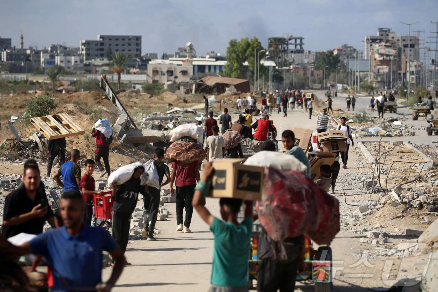 팔레스타인 주민들이 10월 5일 가자 인도주의 재단&#40;GHF&#41;가 운영하는 배급소에서 돌아오고 있다. 2025.10.5./뉴스1 ⓒ AFP=뉴스1 ⓒ News1 이창규 기자