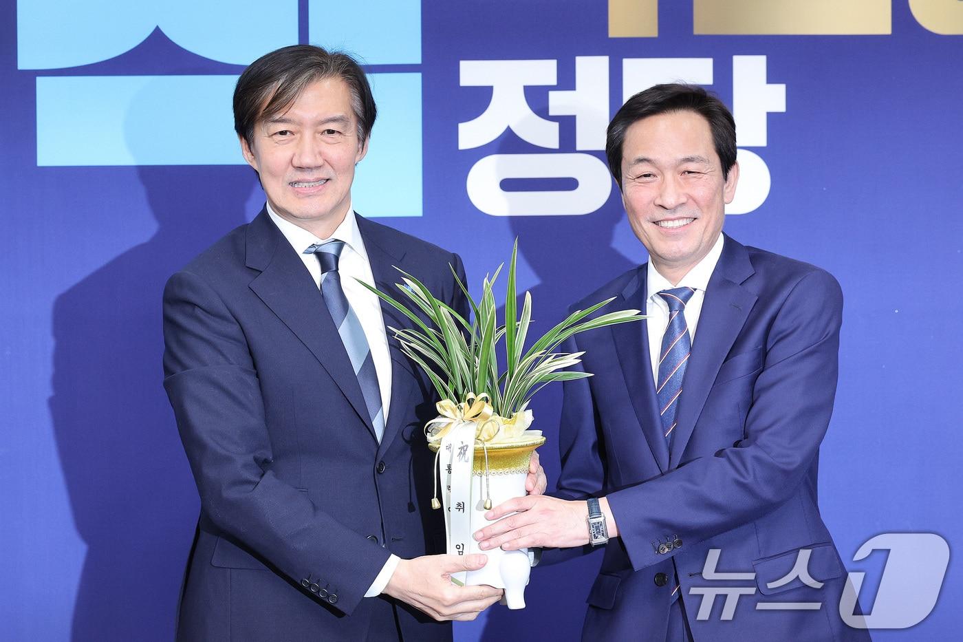 우상호 대통령실 정무수석이 25일 서울 여의도 국회를 찾아 조국 조국혁신당 대표에게 이재명 대통령의 취임 축하난을 전달하고 있다. 2025.11.25/뉴스1 ⓒ News1 신웅수 기자