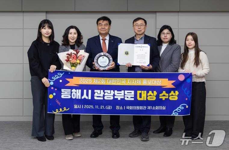 본문 이미지 - 서울 국회의원회관 1소회의실에서 지난 21일 열린 대한민국 지자체 홍보대상 시상식에서 관광부문 대상을 수상한 강원 동해시 관계자들이 심규언 시장(사진 가운데)과 기념촬영을 하고 있다.(동해시 제공, 재판매 및 DB 금지) 2025.11.25/뉴스1