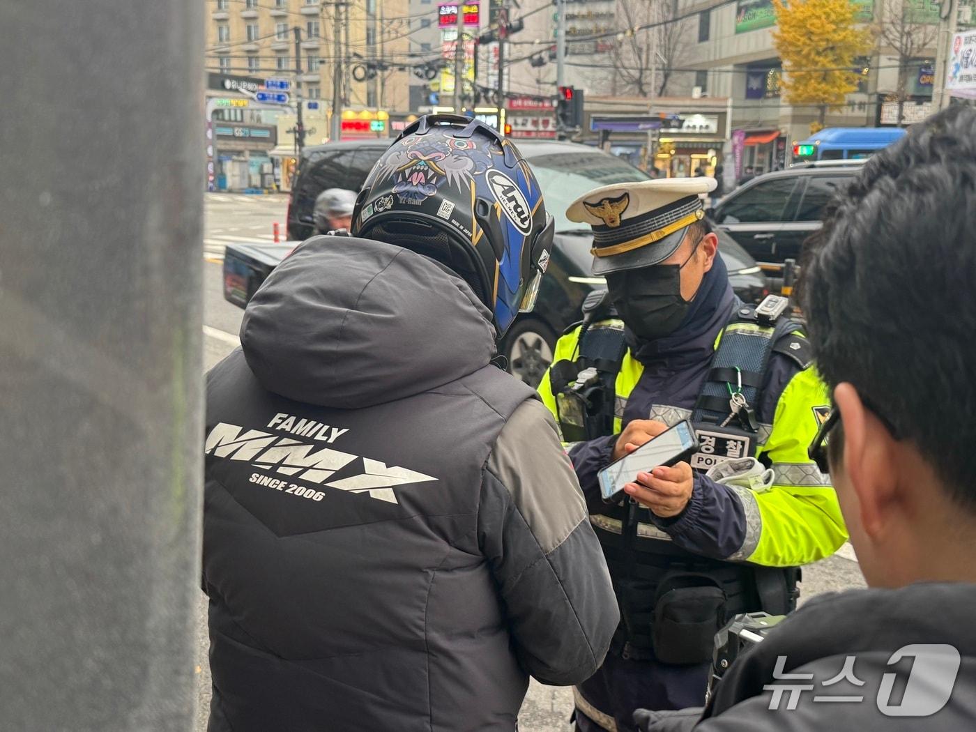 본문 이미지 - 25일 오후 서울 동대문구 회기역 앞 교차로에서 끼어들기 단속에 적발된 운전자에게 경찰이 교통 법규를 설명 중이다. 2025.11.25/뉴스1 ⓒ News1 권준언 기자