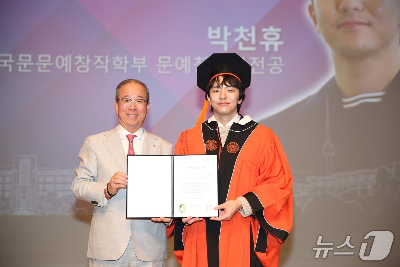 윤재웅 동국대 총장(왼쪽)이 박천휴 작가에게 명예졸업장을 수여 중인 모습.(동국대학교 제공)