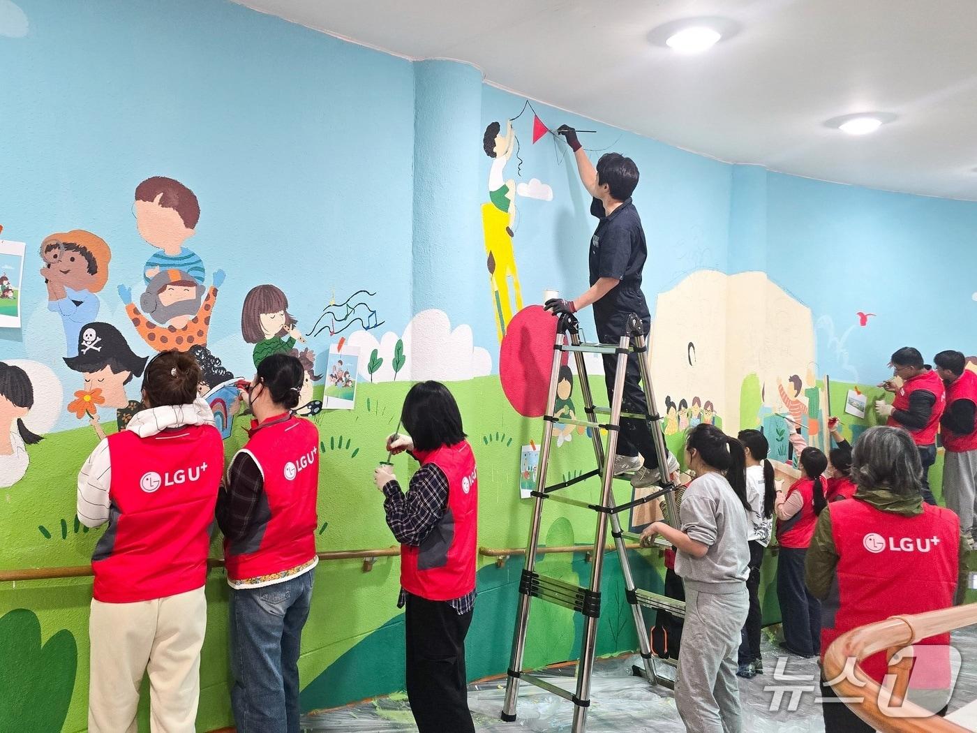 본문 이미지 - LG유플러스가 충북 충주시 충주성모학교에 시각장애 학생들의 독서와 교육을 돕기 위한 U+희망도서관을 구축했다. 사진은 LG유플러스 임직원들이 충주성모학교 담장에 벽화를 그리고 있는 모습. 2025.11.26/뉴스1&#40;LGU+ 제공_