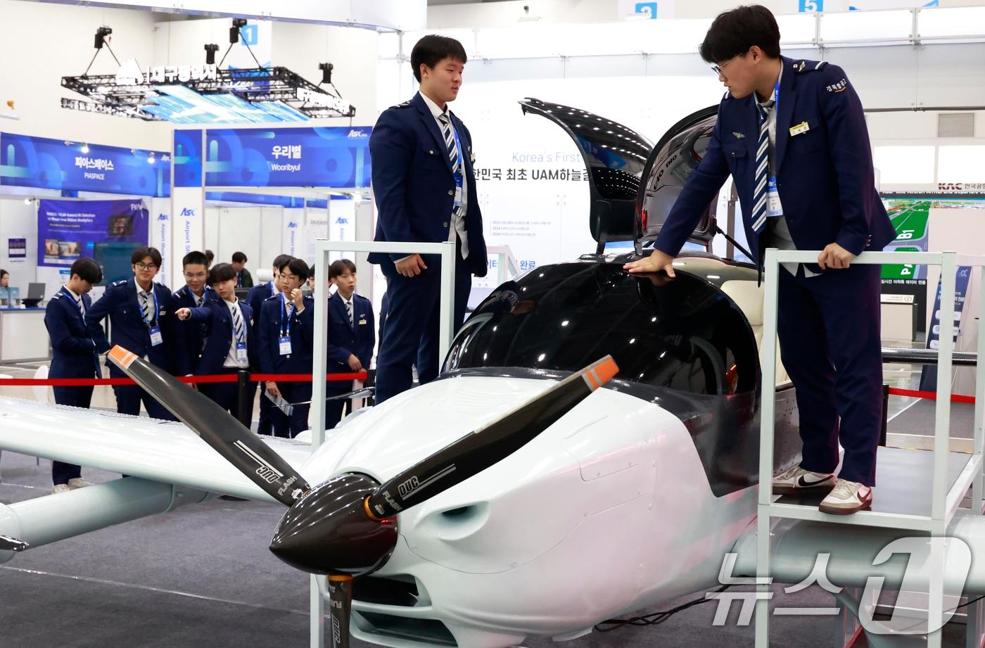 본문 이미지 - (사진은 기사 내용과 무관함) 대구 북구 엑스코(EXCO)에서 개막한 '2025 대한민국 미래공항엑스포'를 찾은 경북항공고 학생들이 4인용 도심항공교통(UAM)을 살펴보고 있다.  2025.11.26/뉴스1 ⓒ News1 공정식 기자
