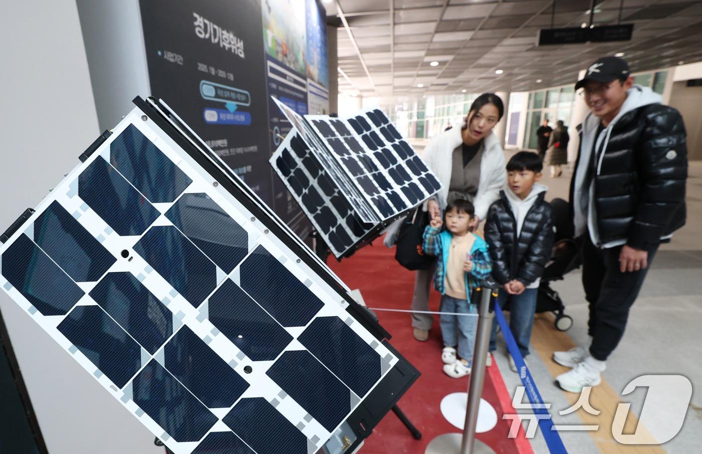 ‘경기기후위성’ 1호기 발사를 하루 앞둔 25일 경기 수원시 영통구 경기신용보증재단 도민쉼터에 마련된 경기기후위성 임시상황실에서 시민들이 &#39;경기기후위성&#39; 모형을 살펴보고 있다. ‘경기기후위성’ 1호기는 한국시간 27일 오전 3시 18분 발사예정이며 스페이스X ‘펠컨9’ 로켓에 실려 발사된다. ⓒ News1 김영운 기자