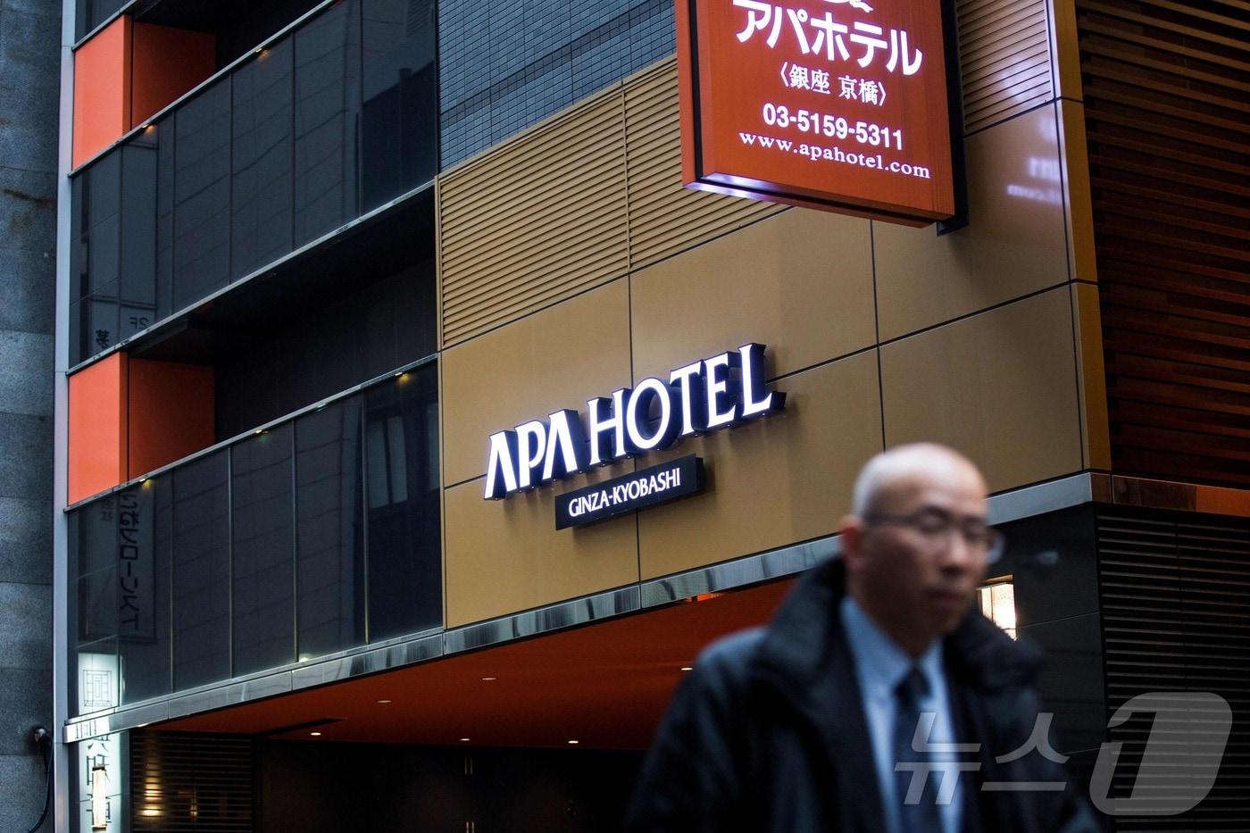 본문 이미지 - 2017년 1월 20일 한 남성이 도쿄 중심부에 있는 아파 호텔(APA Hotel) 앞을 지나가고 있다. 2017.1.20./뉴스1 ⓒ AFP=뉴스1 ⓒ News1 이창규 기자