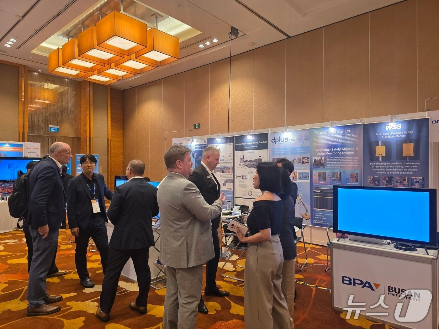 본문 이미지 - TOC 아시아 전시부스에서 부산항만공사의 기술전시부스를 관람중인 참관객들.